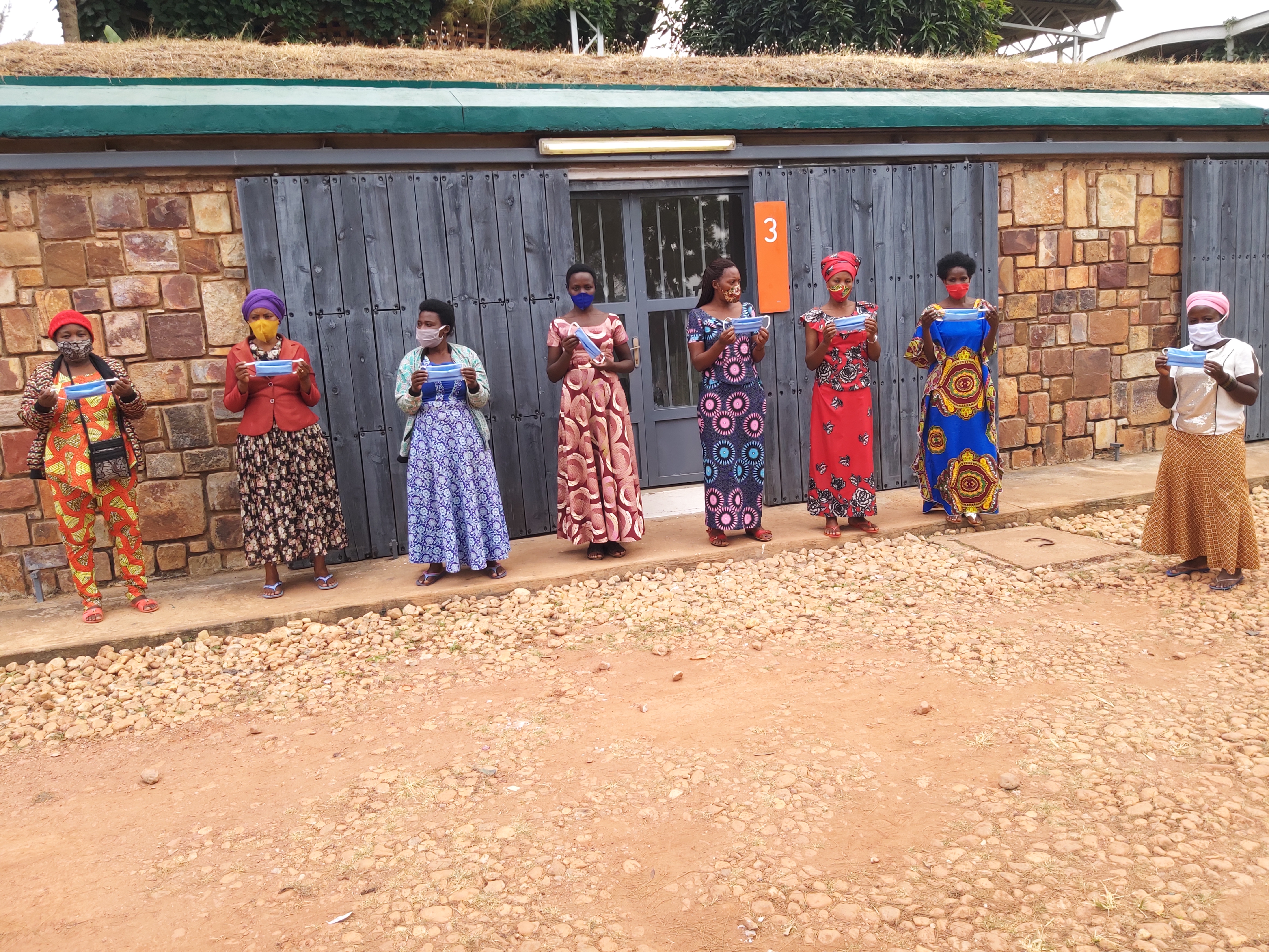 Graduates at the Women's Opportunity Center in Nigeria stand wearing face masks and holding masks that they have made