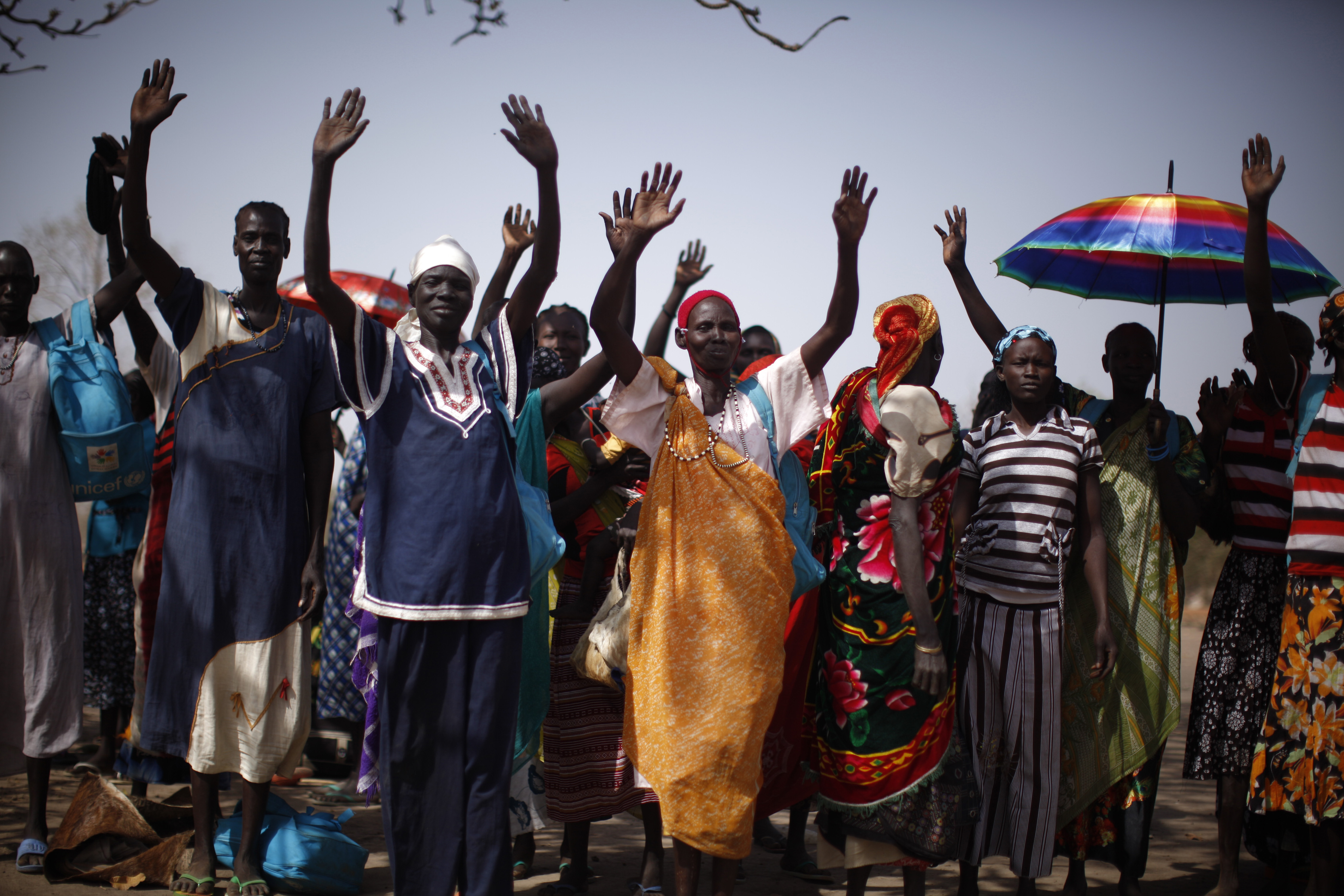 South Sudanese women raise their hands after arriving at the Join Me on the Bridge event